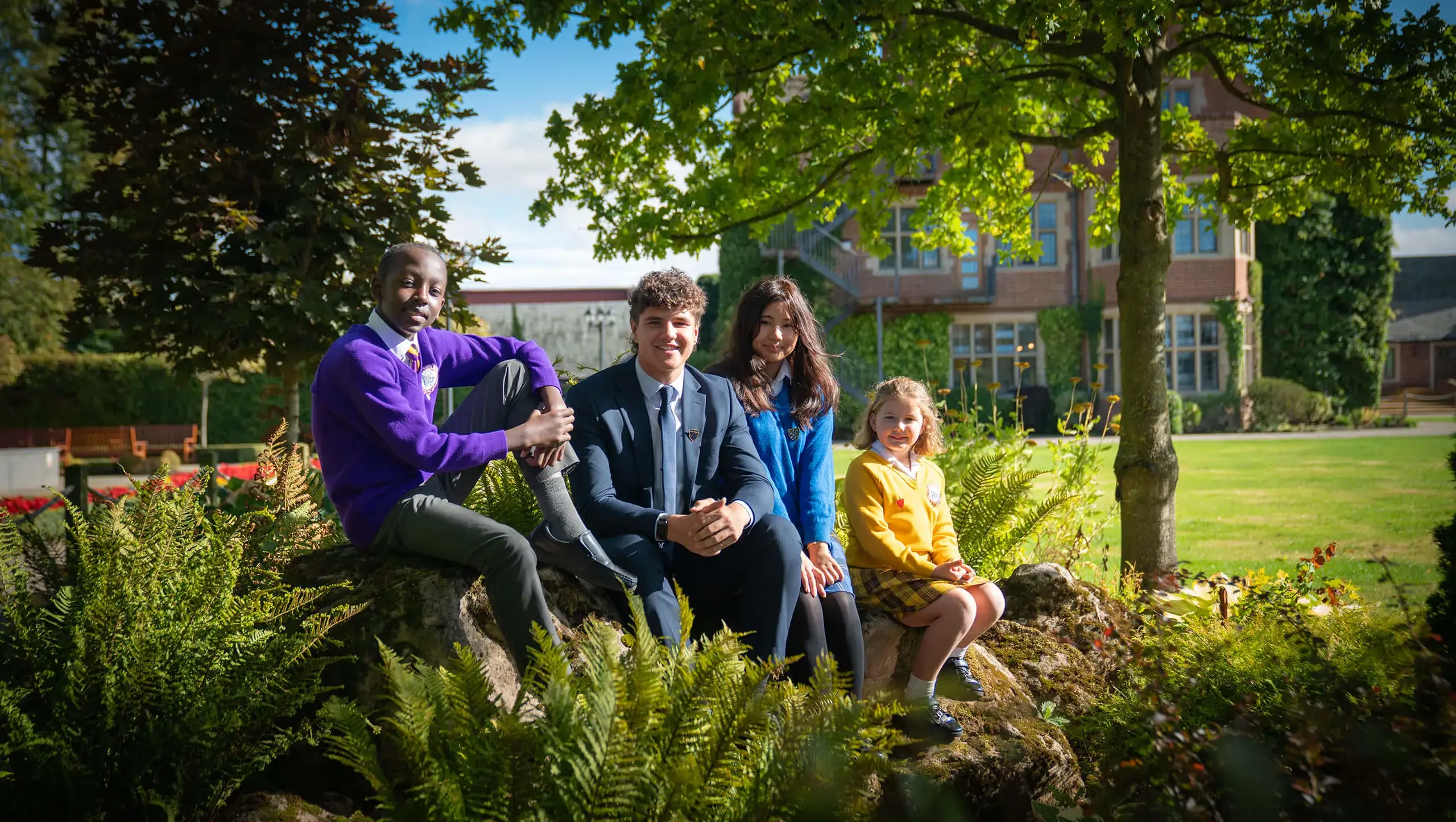 Students from all four day and boarding schools at Queen Ethelburga's sat on a rock.