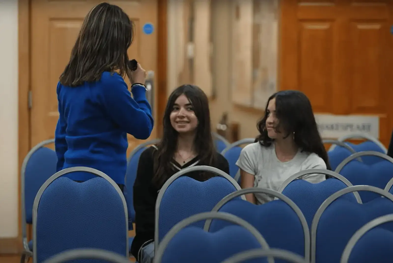Female Key Stage 4 student interviewing other students.