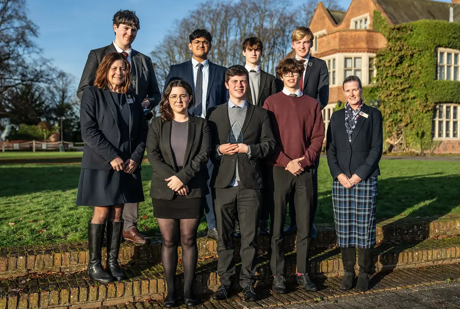 Queen Ethelburga's students celebrating an award with their teachers