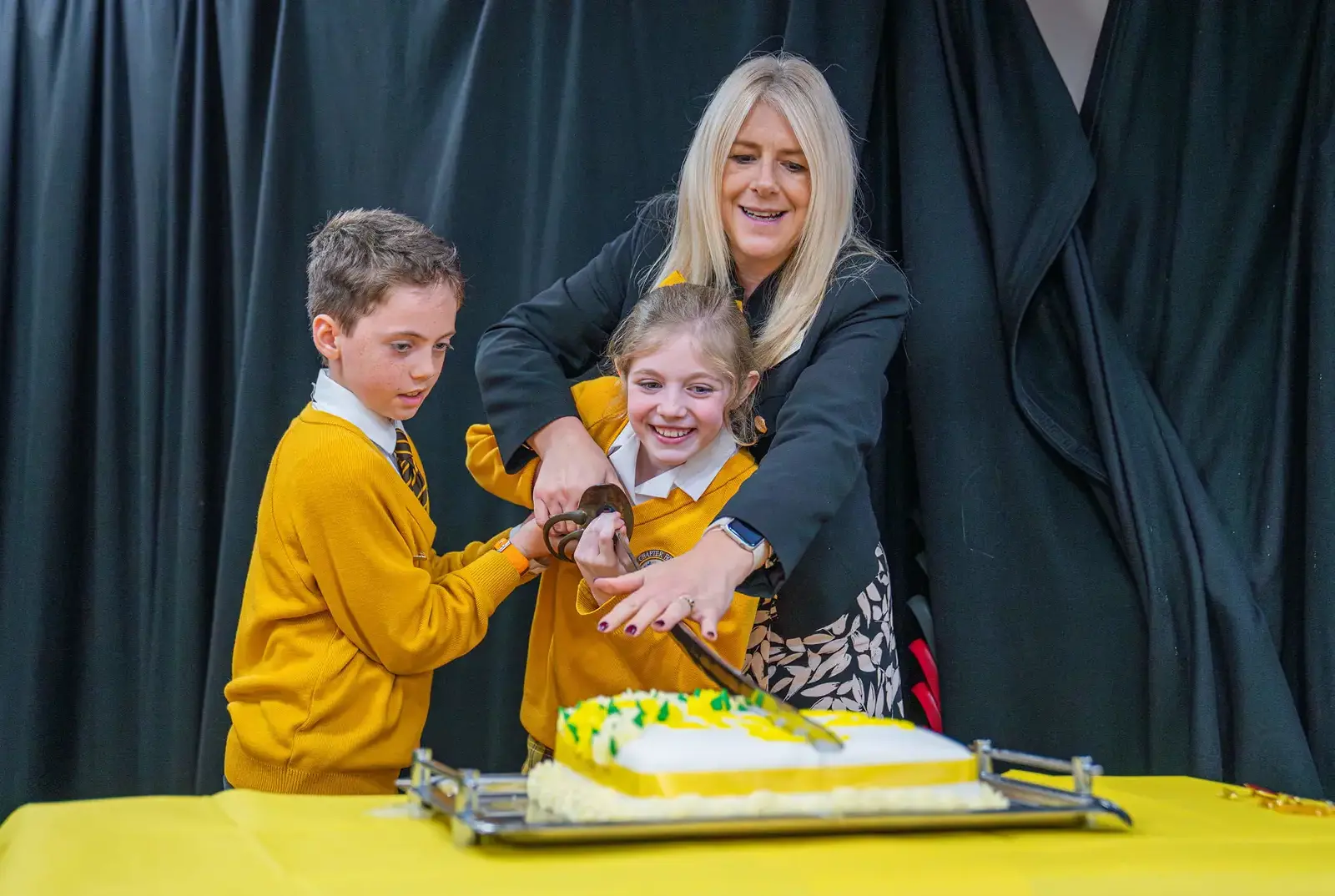 Chapter House celebrating the school birthday by cutting the cake with a sword.