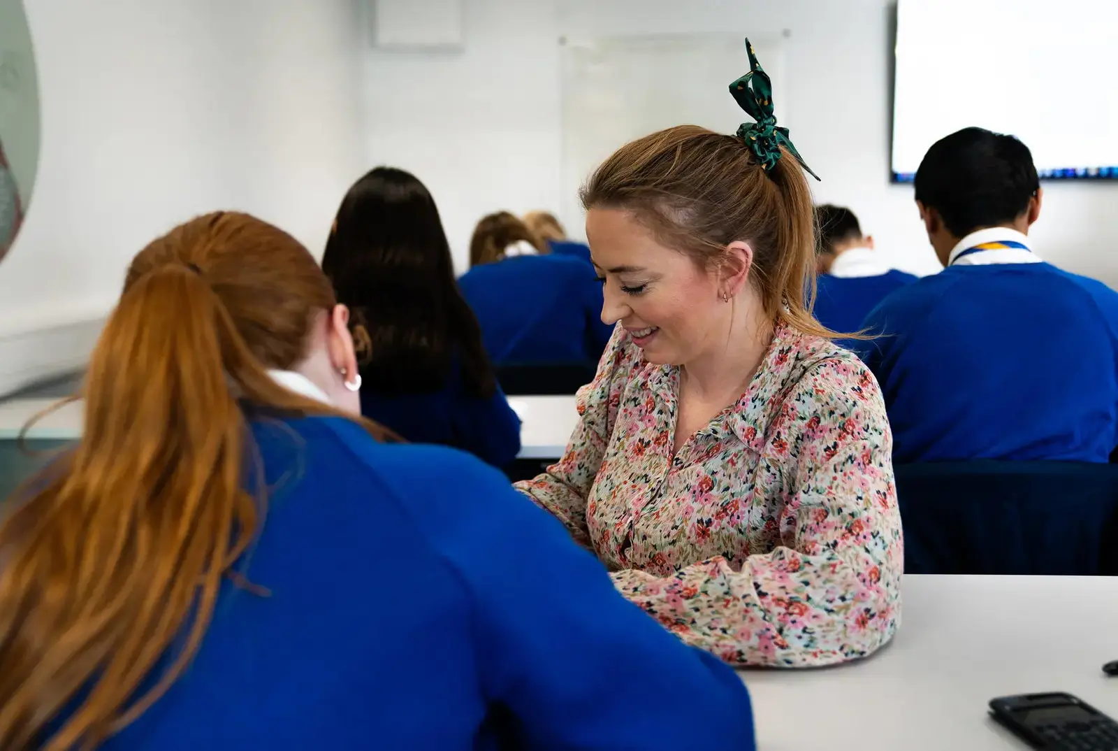 Teacher working with a student at QE College