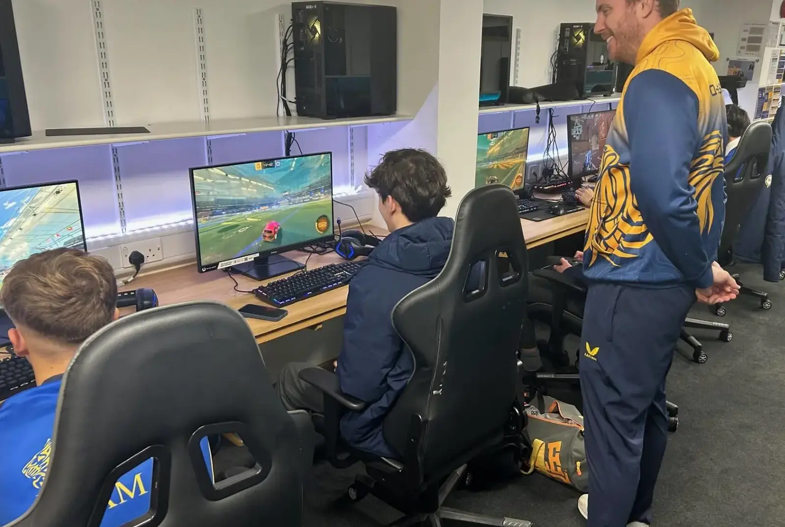 Teacher helping a student in Rocket League Esports competition.