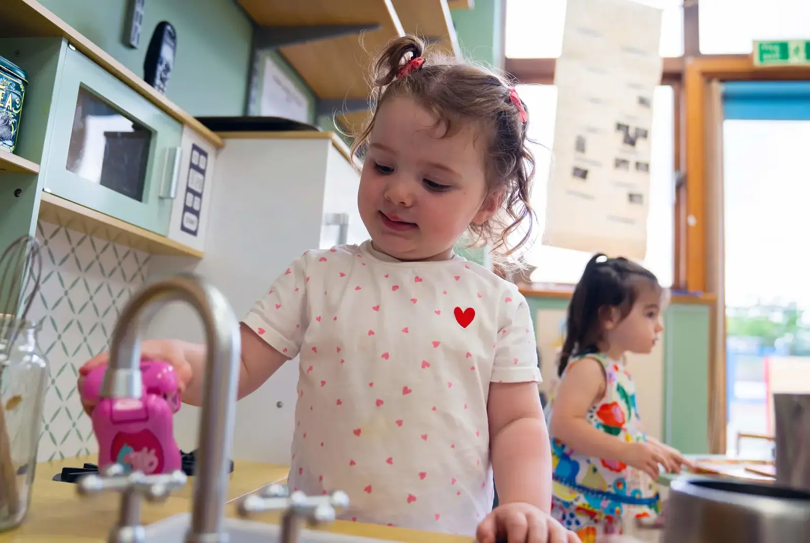 Child playing in the pretend kitchen at Explorers Nursery