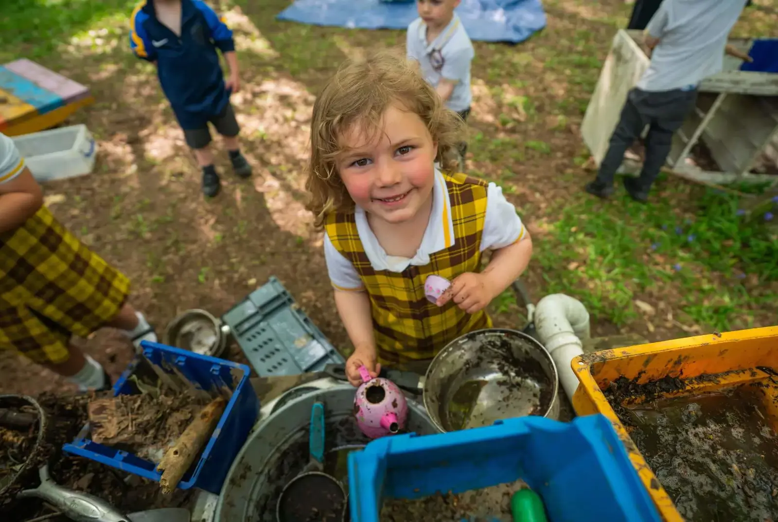 EYFS child playing in the mud kitchen.