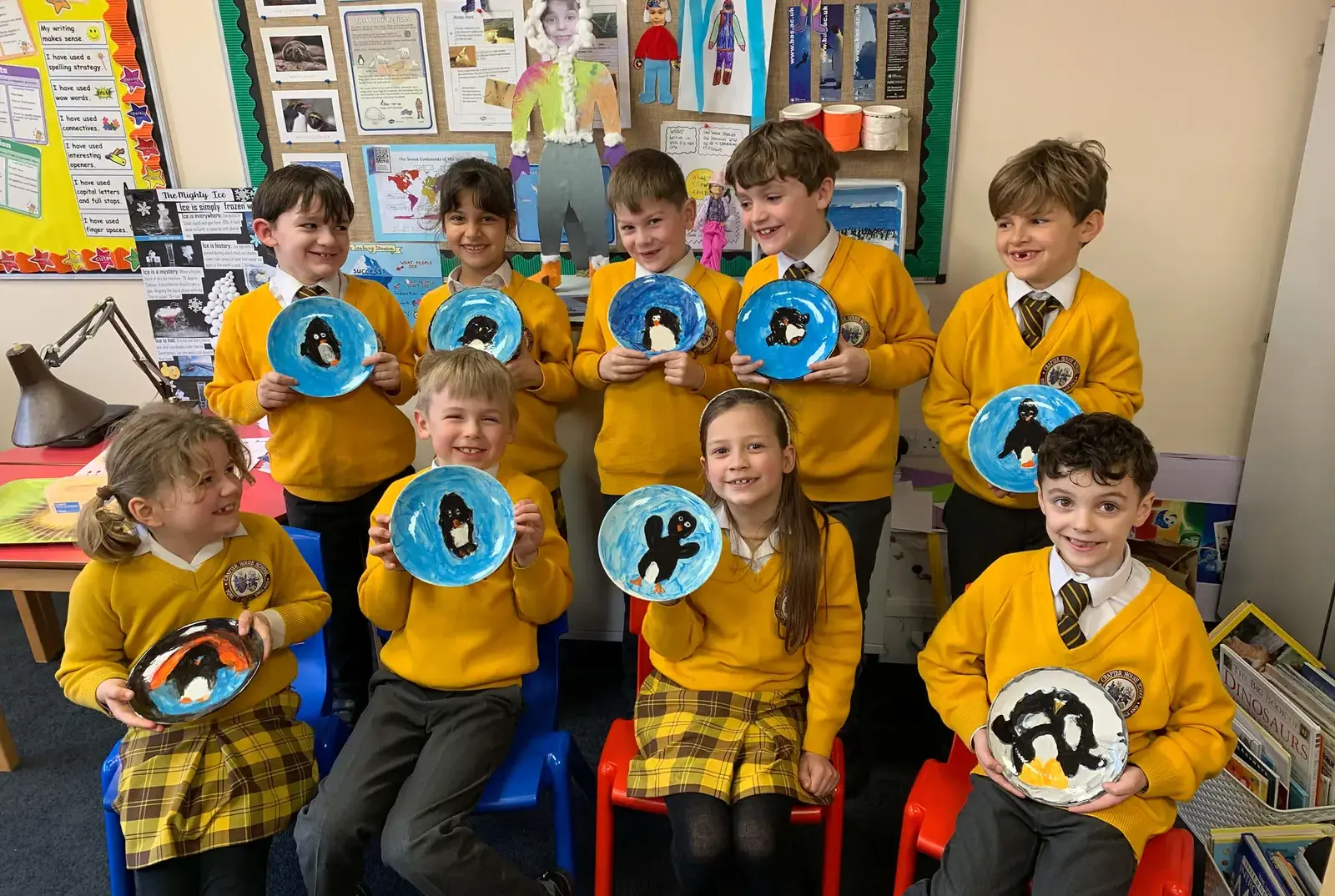Key Stage One pupils holding painted plates at Chapter House, primary school in York.
