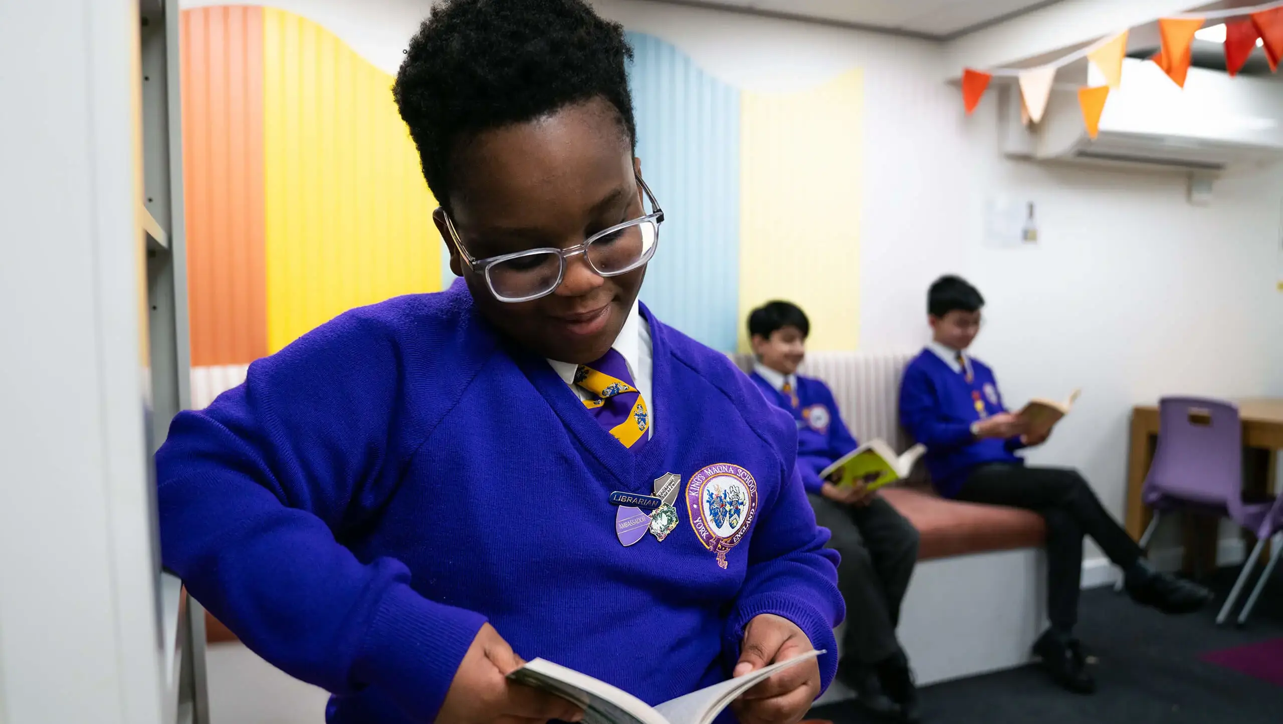 A student reading a book as part of their English lesson.