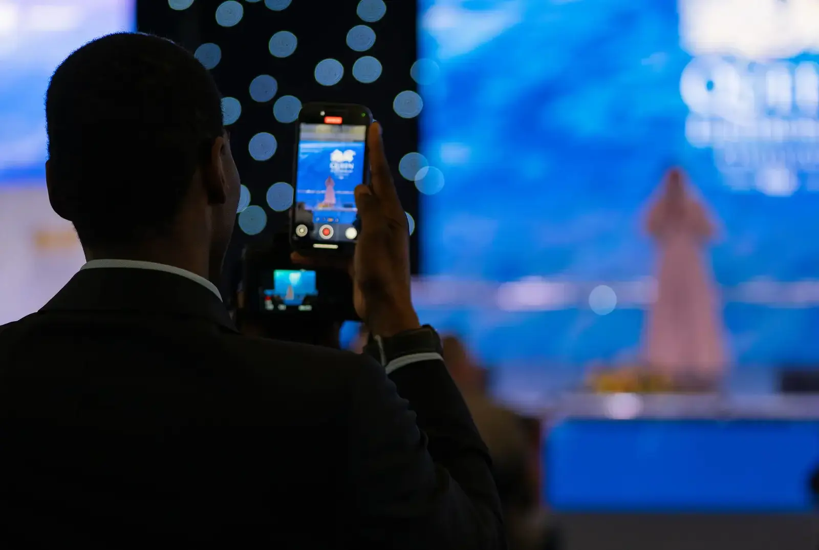 A parent filming their child on Speech Day.