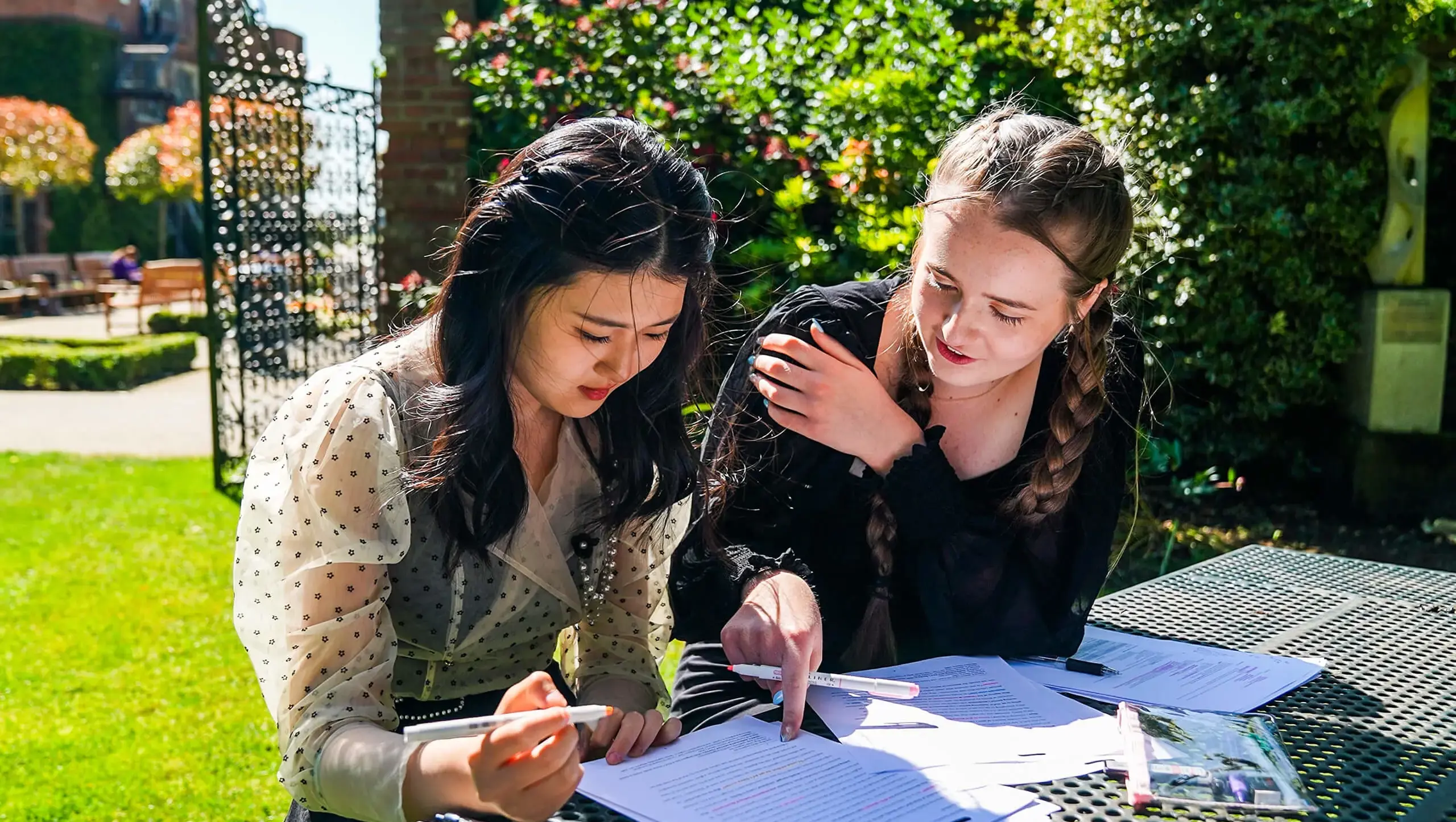 Two students outside Queen Ethelburga's revising as part of the QE Ethos.