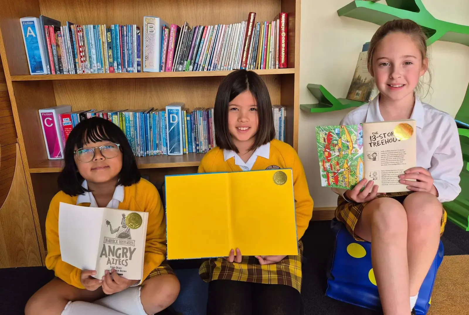 Students sticking stamps in their library books.